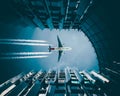 Low angle shot of a plane flying over a modern downtown building leaving a trail Royalty Free Stock Photo