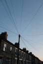 Low angle shot of a post with lots of wires on old buildings background