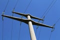 Low angle shot of power transmission masts against a blue sky