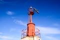 Low-angle shot of a red steel lighthouse top with the blue sky in the background Royalty Free Stock Photo