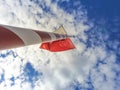 Low angle shot of a red and white flagpole against blue cloudy sky Royalty Free Stock Photo