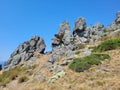 Low angle shot of rock formations on the hill on blue sky background Royalty Free Stock Photo