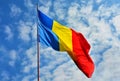 Low angle shot of the Romanian flag under the beautiful clouds in the blue sky Royalty Free Stock Photo