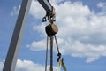 Low angle shot of a rusty pulley with a cloudy blue sky in the background Royalty Free Stock Photo