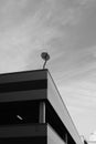 Low angle shot of a satellite dish on top of the building under a cloudy sky Royalty Free Stock Photo