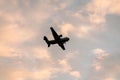 Low angle shot of a silhouette of the Coronado San Diego military airplane flying in a sunset sky