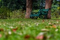 Low angle shot of sitting bench placed under two trees in the park. relaxation concept Royalty Free Stock Photo