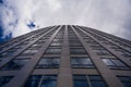 Low-angle shot of a skyscraper rising against the cloudy sky