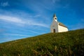 Low angle shot of a small church on a rural green hill in the Netherlands Royalty Free Stock Photo