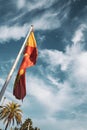 Low Angle Shot Of The Spanish Flag Fluttering In The Wind Against A Blue Sky