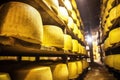low angle shot of stacked cheese rounds in aged cellar