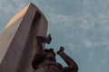 Low angle shot of a statue of a female under gloomy cloudy sky