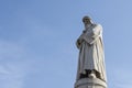 Low angle shot of a statue of Leonardo Da Vinci with a blue clear sky behind in Milan, Italy Royalty Free Stock Photo