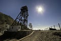 Low angle shot of sun over a wooden tower on the mines against a clear blue sky Royalty Free Stock Photo