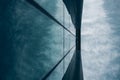 Low angle shot of a tall building in a glass facade under a cloudy sky Royalty Free Stock Photo