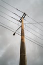 Low-angle shot of the tall electric pole with telephone wires extending from the top Royalty Free Stock Photo