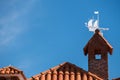 Low angle shot of a terracotta roof with a beautiful white boat weathervane decoration Royalty Free Stock Photo