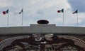 Low angle shot of the top of a university football stadium with four Mexican flags