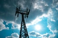 Low angle shot of a transmission tower against white fluffy clouds in bright blue sky Royalty Free Stock Photo
