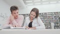 Low angle shot of two college friends enjoying studying together at the library