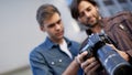 Two friends discussing their photographs. Low angle shot of two men looking at the lcd screen on a digital camera. Royalty Free Stock Photo