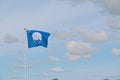 Low angle shot of the waving blue beach flag under a cloudy sky