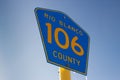 Low angle shot of yellow and blue pentagon-shaped Rio Blanco 106 County road sign