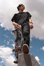 Low angle view skater standing with his skateboard with the sky in the background Royalty Free Stock Photo