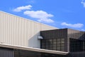 brown office on white corrugated metal industrial building against white clouds in blue sky Royalty Free Stock Photo