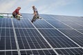Male workers installing solar panel on metal construction. Royalty Free Stock Photo