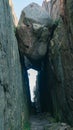 Low angle vertical closeup view of a big rock stuck in between two close cliffs