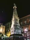Low angle vertical shot of a monumental column in Naples, Italy at night