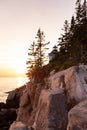 Low angle vertical view of rocky cliff and lighthouse at sunset, Bass Harbor Royalty Free Stock Photo