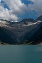 Low angle vertical of Zillergrund statuses with snowy mountains, clouds, and blue sky background Royalty Free Stock Photo