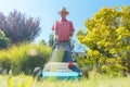 Active senior man smiling while using a grass cutting machine