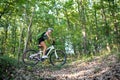 Low angle view of active senior woman biker cycling outdoors in forest. Royalty Free Stock Photo