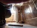 Low angle view of adult male plumber working repairing disassembling old vintage Royalty Free Stock Photo