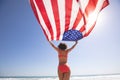 Woman in bikini holding american flag on the beach Royalty Free Stock Photo