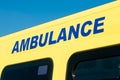 Blue AMBULANCE sign on yellow NHS vehicle. Royalty Free Stock Photo