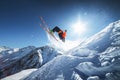 Low angle view athlete skier in an orange jacket does a back flip with flying powder of snow against a clear blue sky