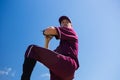 Low angle view of baseball pitcher throwing ball against blue sky Royalty Free Stock Photo