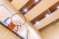 Low angle view of Basketball hoop in Gym with ceiling spotlight, Sport arena background with copy space Royalty Free Stock Photo