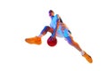 Low angle view. Basketball player performing dynamic dribbling in jump against white studio background in neon light. Royalty Free Stock Photo