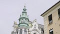 Low angle view of a beautiful building with light turquoise dome of a tower. Action. Concept of architecture, street of