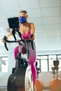 Female athlete with oxygen mask exercising with exercise bike in fitness studio