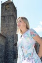 Low angle view of a blonde woman smiling. There`s an old church in the background Royalty Free Stock Photo