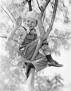 Low angle view of a boy sitting on a tree Royalty Free Stock Photo