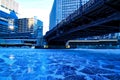Low-angle view of bridge crossing a frozen Chicago River on a blue, frigid morning in winter.