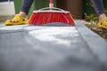 Broom pushing special sand into tile gaps on a newly paved patio with concrete tiles