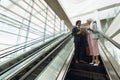 Business people with bags discussing over digital tablet on escalator in a modern office Royalty Free Stock Photo